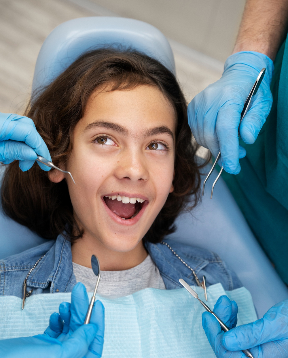 Enfant souriant lors d'une consultation de pédodontie avec une équipe dentaire à Chadi Dental Clinic à Casablanca.